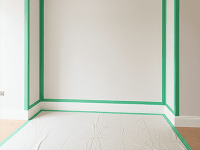 A wall with green painter's tape creating a perfect rectangle, ready for a feature wall.