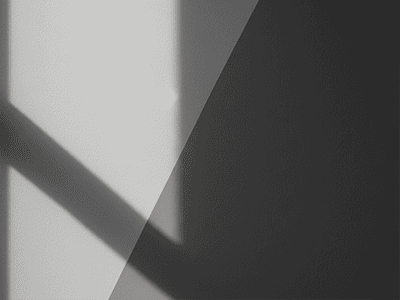 A single grey wall, half in bright sunlight looking cool, and half in shadow looking warm.